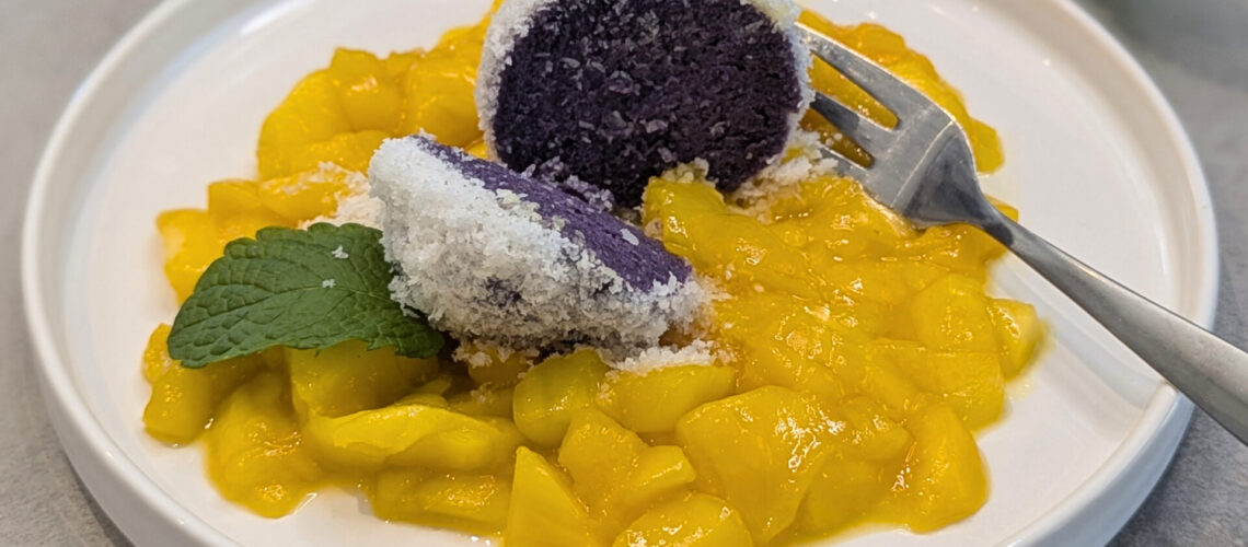 Kokos-Quarkknödel auf warmem Mangosalat