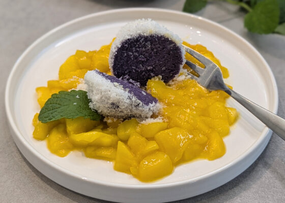 Kokos-Quarkknödel auf warmem Mangosalat